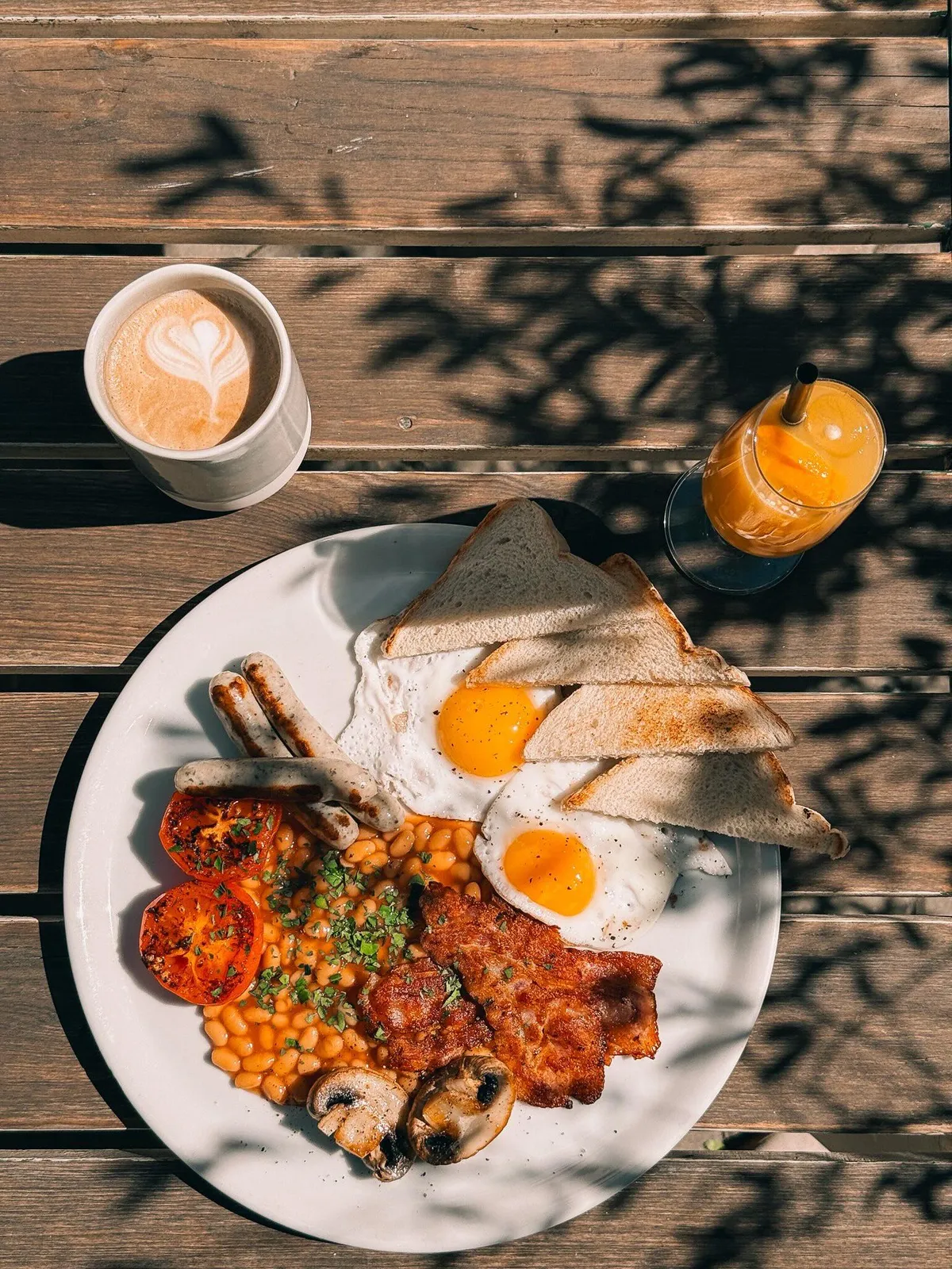 Anglická snídaně na dřevěném stole: vejce, fazole, slanina, toast